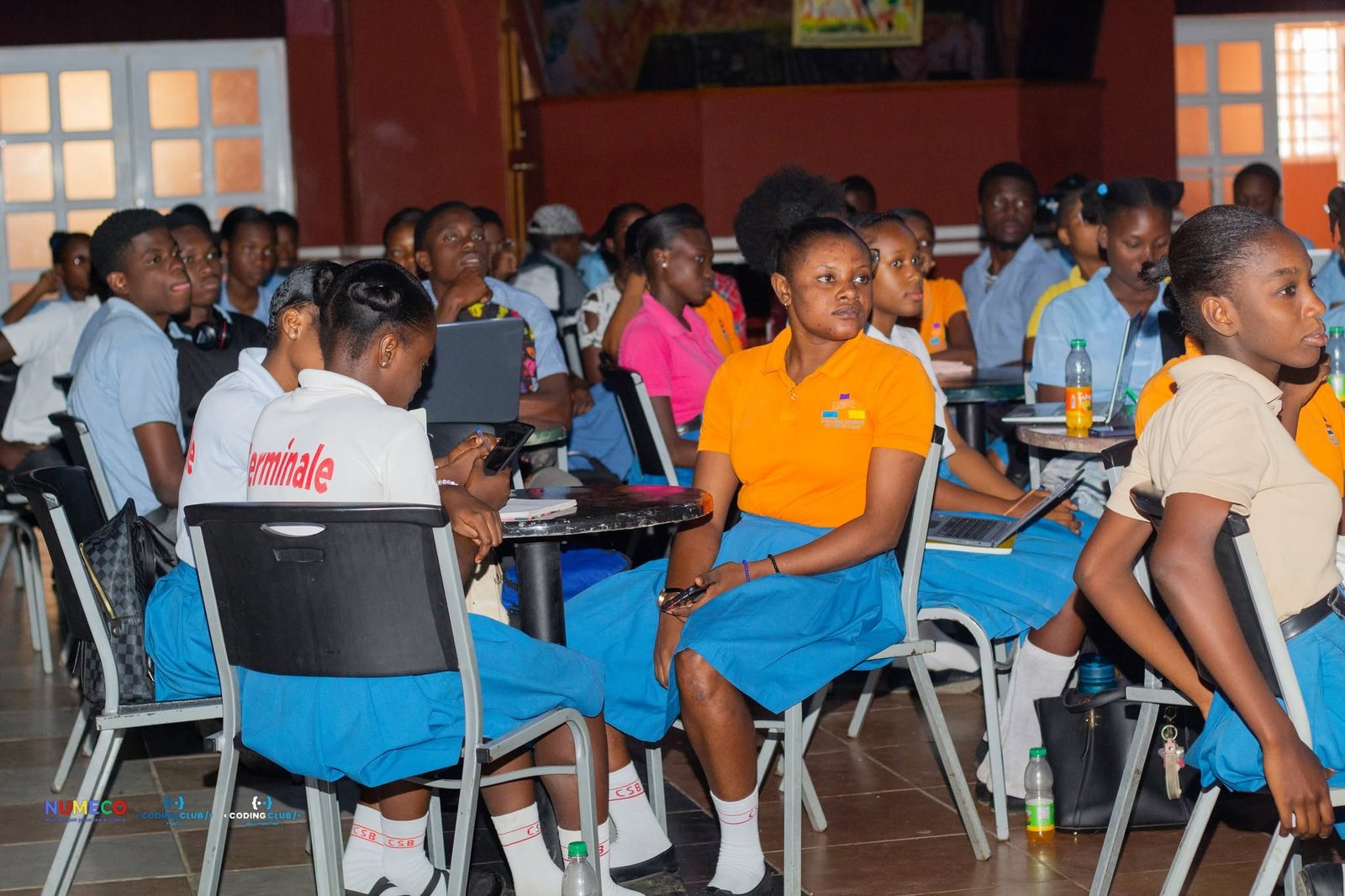 Élèves en uniforme suivant une session NUMECO en salle